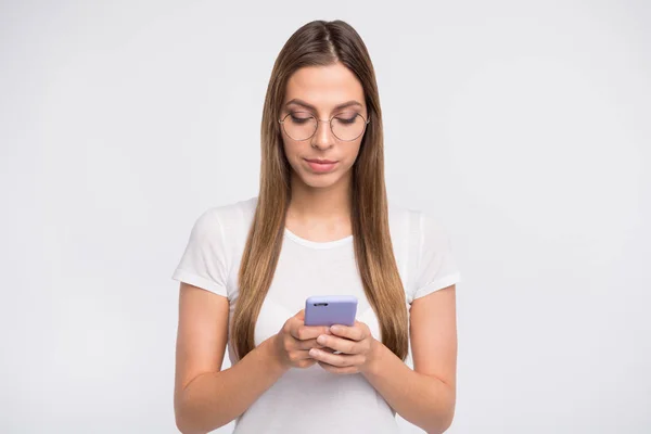 Amazing Lady houden telefoon handen geconcentreerd op lezing slijtage specs en casual t-shirt geïsoleerd witte achtergrond — Stockfoto