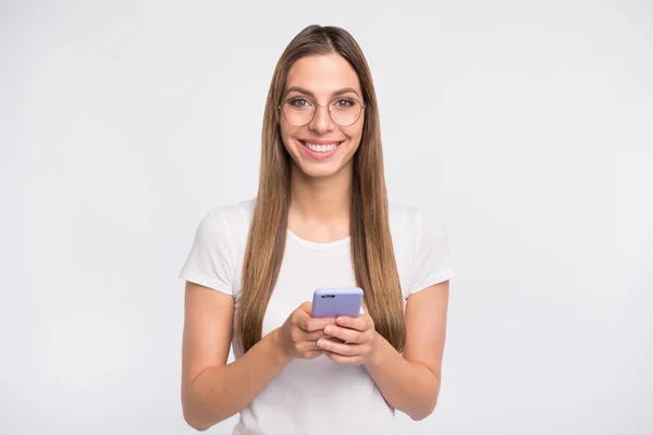 Amazing Lady houden telefoon in handen toothy glimlachend slijtage specs en casual t-shirt geïsoleerd witte achtergrond — Stockfoto