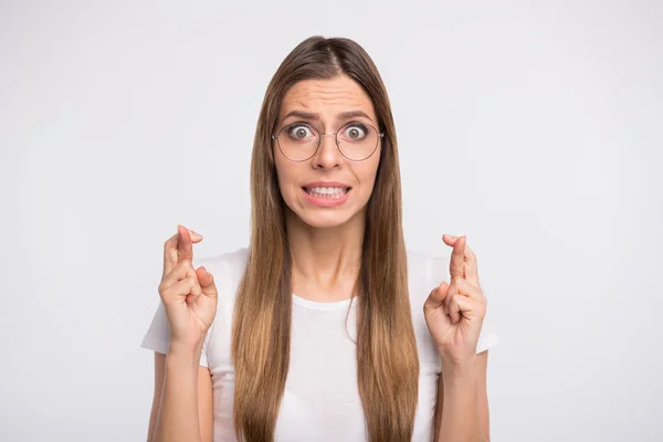 Foto de senhora segurando dedos cruzados antes do exame final desgaste especificações e casual t-shirt isolado fundo branco — Fotografia de Stock