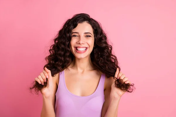 Foto von fröhlichen netten netten ekstatischen Freundin hält Enden ihres Haares, während isoliert mit rosa Hintergrund — Stockfoto