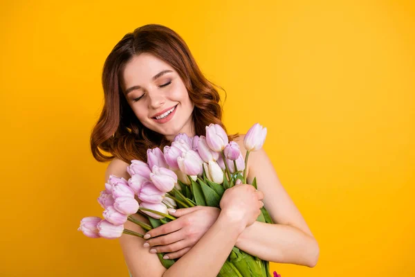 Fotó elég boldog hölgy gazdaság nagy rakás rózsaszín tulipán a fegyverek kopás tank tetején elszigetelt sárga háttér — Stock Fotó