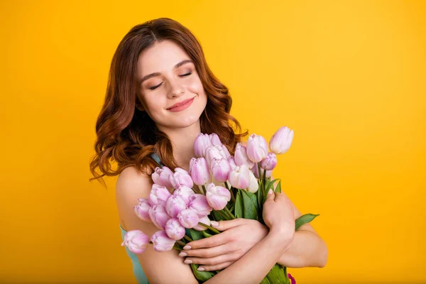 Foto de senhora bonita segurando grande monte de tulipas rosa em mãos usar tanque-top isolado fundo amarelo — Fotografia de Stock