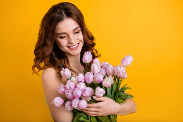 Foto de senhora bonita segurando grande monte de tulipas rosa em mãos usar tanque-top isolado fundo amarelo — Fotografia de Stock