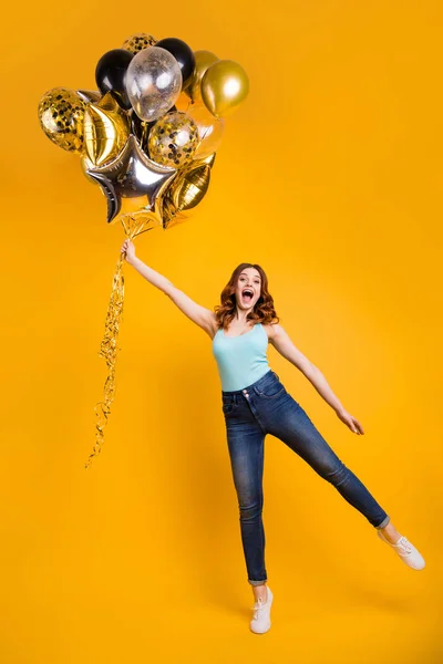 Foto vertical de longitud completa de la señora que tiene el mejor tiempo con globos de aire en las manos usan traje casual aislado fondo amarillo — Foto de Stock