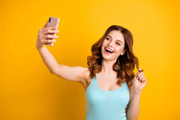 Фото забавной леди, держащей телефон в руке и делающей фотографии для Instagram носить топ-изолированный желтый фон — стоковое фото