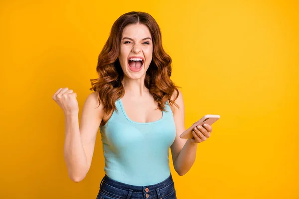 Photo of excited lady holding telephone celebrating social group online winning wear tank-top isolated yellow background
