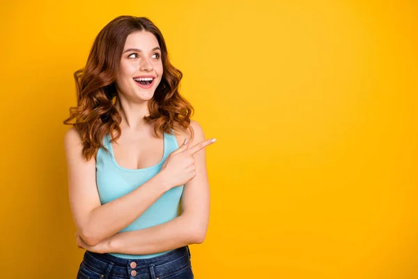Copyspace photo of charming cute nice cheerful emotional sweet gorgeous girlfriend wearing jeans denim teal singlet while pointing away at emptiness isolated with yellow vivid color background — Stock Photo, Image