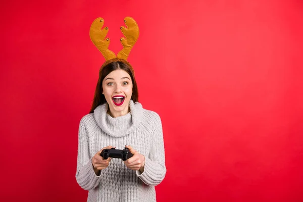 Signora infantile giochi in vigilia di Natale indossare testa di cervo corna e maglia maglione isolato sfondo rosso — Foto Stock