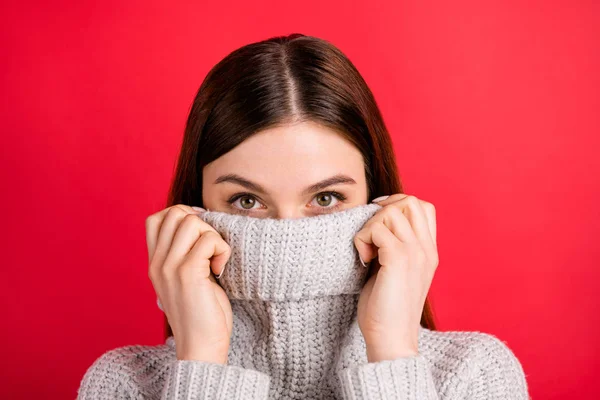 漂亮的女士隐藏半面部表情与温暖的针织毛衣的衣领隔离在红色背景 — 图库照片