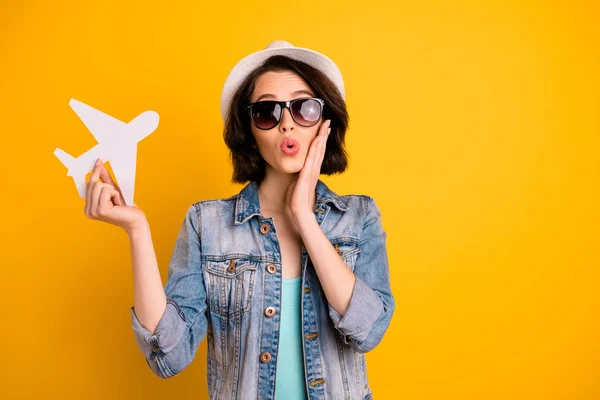 Foto de encantadora alegre agradável engraçado funky menina vestindo boné mostrando-lhe brinquedo avião que ela vai voar no exterior por enquanto isolado com fundo vívido — Fotografia de Stock