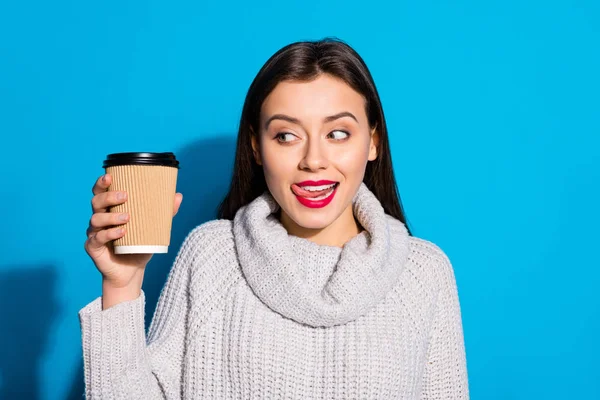 Retrato de jovem encantador segurando café expresso bebida quente olhando vestindo camisola cinza isolado sobre fundo azul — Fotografia de Stock