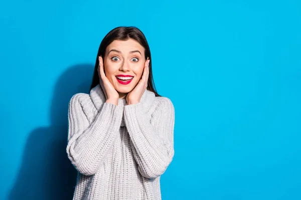 Portrait of pretty lady shouting looking at camera touching her face wearing gray sweater isolated over blue background — 스톡 사진