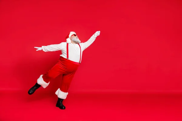 Foto in voller Länge von schönen Licht wie eine Feder oder Ballerina tragen Hosenträger weißen Pullover schwarze Schuhe halten die Hand nach oben fangen Zeit zu fliegen noel isoliert hellen Hintergrund — Stockfoto