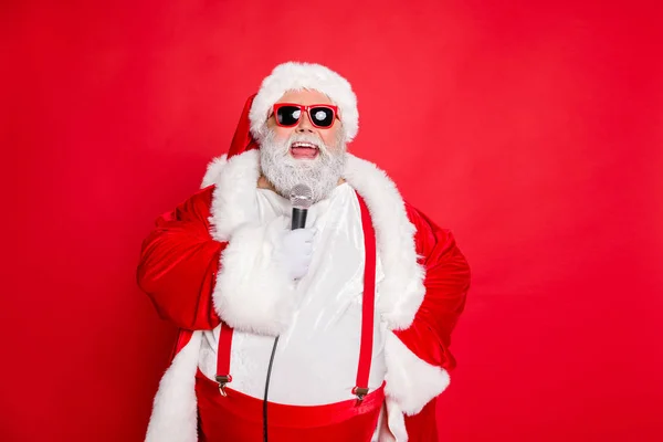 Close-up foto van vrolijke grappige Fat pop ster Kerstman met grote buik in hoofddeksels hoed zingen liedjes dragen stijlvolle stijl trendy brillen brillen geïsoleerd over rode achtergrond — Stockfoto