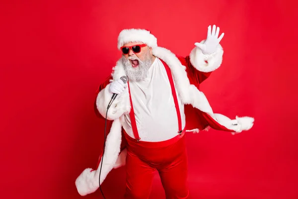 Porträt von coolen lustigen fetten übergewichtigen Weihnachtsmännern mit dickem Bauch singen Song auf Weihnachtsfeier tragen Stil stilvolle trendige Brillen Brillenhut isoliert über rotem Hintergrund — Stockfoto