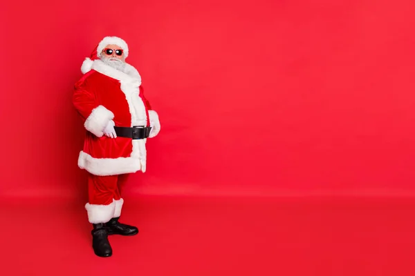 Full length photo of minded cool funky fat santa claus with big belly ready to carry presents on christmas eve have boots belt isolated over red background — 图库照片