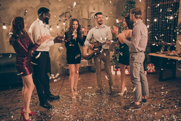 Foto de larga duración del grupo de estudiantes oyen pop comienza a tocar la guitarra disfrutar de la fiesta de Navidad x-mas noche en casa con confeti cayendo en el interior — Foto de Stock