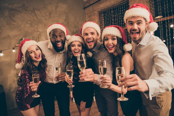 Retrato de inclinação cara e senhoras desfrutar da noite de Natal comemorar x-mas noel dar torrada gritando vestindo calças vestido camisa boné em casa com decoração iluminação ano novo dentro de casa — Fotografia de Stock