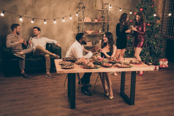 Volledige grootte foto van charmante liefhebbers houden Champagne hebben plezier spreken genieten van kerstfeest x-mas nacht Nieuwjaar feest in huis met verlichting verlichting binnenshuis — Stockfoto