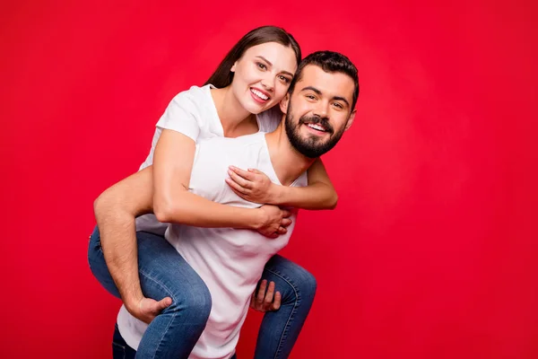 Foto von fröhlich niedlich schön attraktiv trendy huckepack schöne schöne Paar trägt Jeans-Jeans, während isoliert mit rotem Hintergrund — Stockfoto