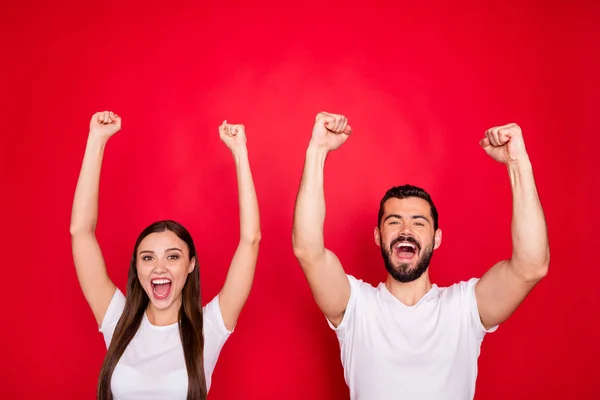 Foto de alegre excitado lindo encantador bonito par de dos personas juntos regocijándose con la victoria de su equipo deportivo favorito con camiseta blanca mientras está aislado con fondo rojo —  Fotos de Stock