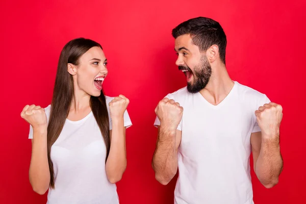 Foto de alegre encantador bonito fascinante elegante bonito casal bonito de duas pessoas se alegrando com a vitória de algo enquanto vestindo t-shirts brancas isoladas com fundo vermelho — Fotografia de Stock