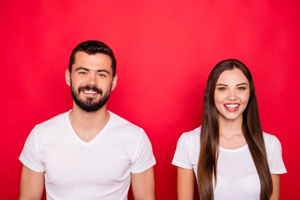 Foto de encantador bonito bonito bonito belo casal olhando para você enquanto isolado com backgroung vermelho com t-shirts brancas — Fotografia de Stock