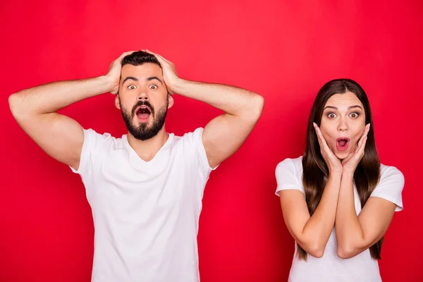 Foto de dos elegantes divertidos divertidos divertidos alegres alegres personas con camisetas blancas regocijándose con descuentos en centros comerciales mientras están aislados sobre fondo rojo — Foto de Stock