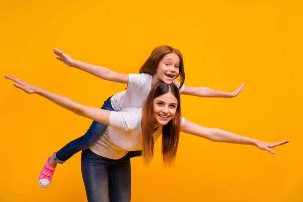 Porträtt av två snygga attraktiva vackra glada munter barnslig lekfull person ha kul semester helgen flyger som planet isolerade över ljusa levande glans gul bakgrund — Stockfoto