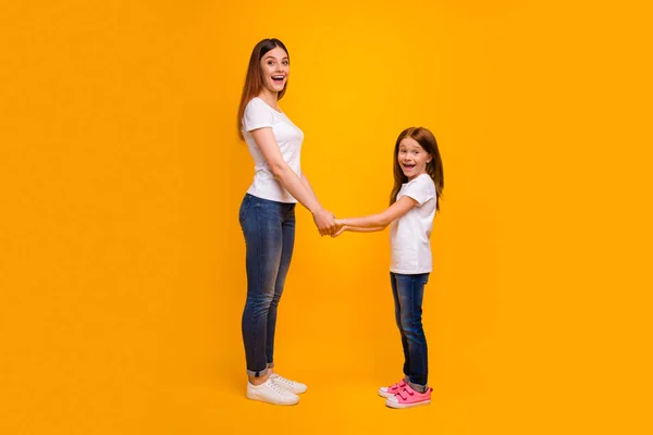 Foto lateral de perfil tamanho completo de mãe impressionada segurando seu filho com longo penteado foxy gritando vestindo camiseta branca isolada sobre fundo amarelo — Fotografia de Stock