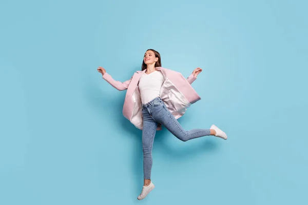 Pleine longueur photo de charmante fille mignonne saut courir pour les bonnes affaires sur son vêtement de vacances jeans denim manteau rose isolé sur fond bleu — Photo