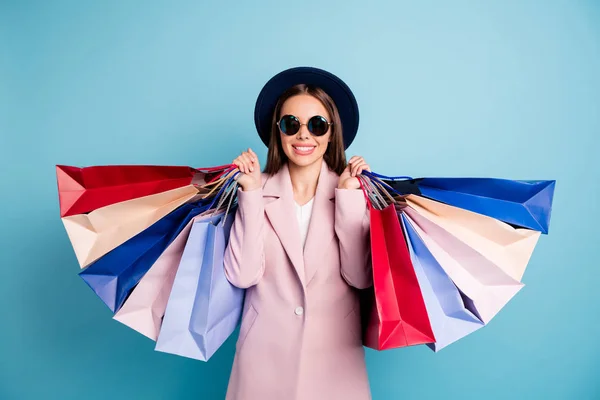 Retrato de linda dama franca en gafas gafas van de compras tienen muchas bolsas de disfrutar de su descanso usan abrigo rosa aislado sobre fondo azul —  Fotos de Stock