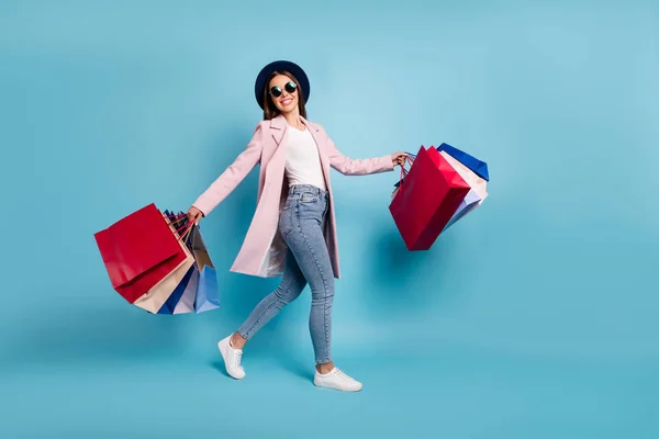 Foto de longitud completa de alegre señora funky turista en gafas gafas ir de compras comprar descuento ventas desgaste rosa retro chaqueta vintage vaqueros aislados sobre fondo azul — Foto de Stock