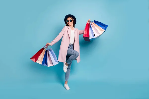 Full body foto di entusiasta candida signora in occhiali occhiali andare a fare shopping acquistare acquisti usura cappotto rosa jeans denim isolato su sfondo blu — Foto Stock