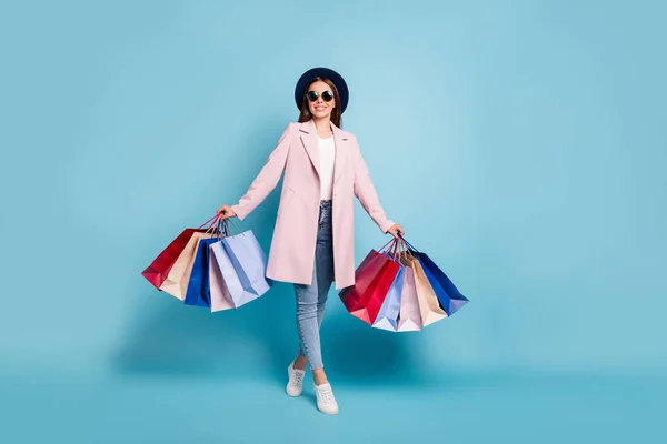 Foto in voller Größe von schönen lustigen Mädchen an ihren Wochenenden einkaufen gehen Geschenke Souvenirs tragen Vintage-Saison Mantel Jeans Brille Brille isoliert über blauem Hintergrund — Stockfoto