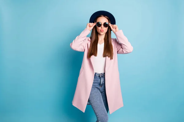 Retrato de menina bonita em óculos eyewear ter data com namorado enviar-lhe beijos de ar desgaste rosa top coat jeans jeans isolado sobre fundo azul — Fotografia de Stock