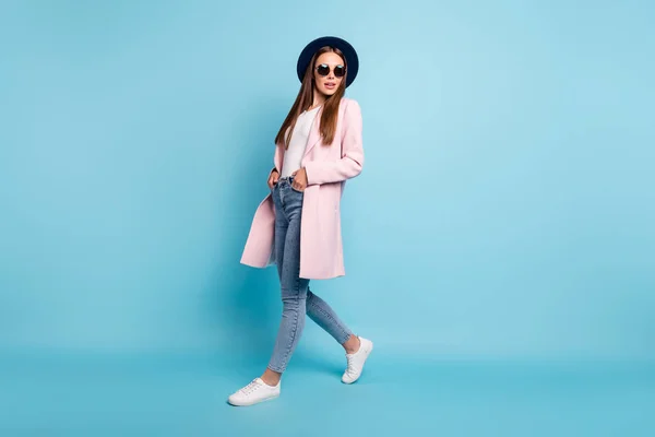 Foto de comprimento total de bonito encantador senhora andando tendo calçadão vestindo cor pastel top coat jeans jeans isolado sobre fundo azul — Fotografia de Stock