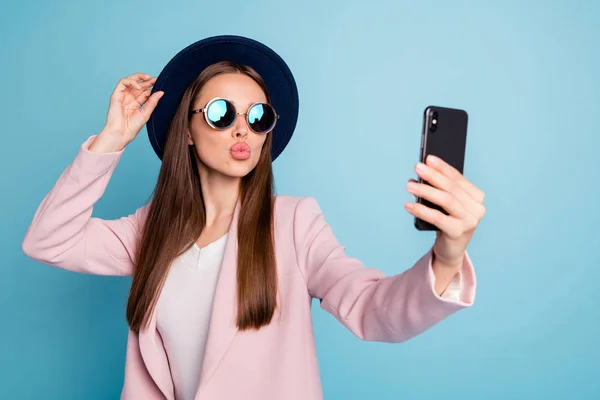 Porträt eines verträumten netten Mädchens, das sein Handy benutzt, um ein Selfie zu machen und Luftküsse zu senden, die den Blog-Stream starten. — Stockfoto