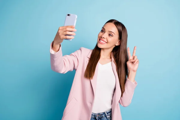 Retrato de linda menina engraçada doce com cabelo comprido fazendo selfie fazendo v-sinais blogging vestindo roupa rosa isolado sobre fundo azul — Fotografia de Stock