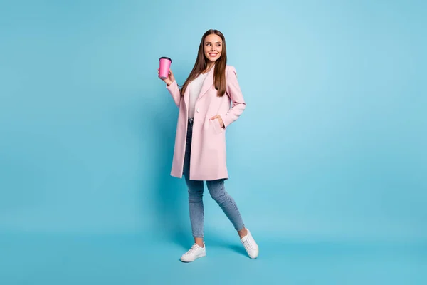 Full size photo of lovely cute cheerful girl having walk promenade holding mug wearing coat denim jeans isolated over blue background — Stock Photo, Image