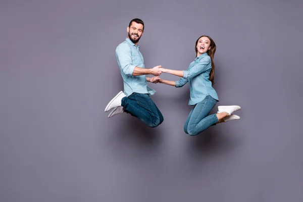 Foto de tamaño completo de encantador salto de estudiante agarrar las manos usar jeans camisa aislada sobre fondo gris — Foto de Stock