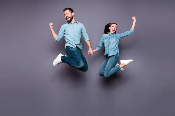 Çılgın insanların tam vücut fotoğrafı yumrukları yükseltmek yükseltmek evet zafer kutlamak gri arka plan üzerinde izole denim kot giymek — Stok fotoğraf