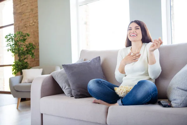 Ritratto di lei lei bella attraente affascinante allegro allegro felice donna positiva seduta in posizione loto sul divano guardando serie divertente mangiare snack mais in luce bianco interno soggiorno al chiuso — Foto Stock