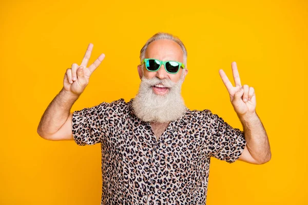 Portrait de joyeux drôle funky vieil homme barbu Voyage sur le voyage profiter du voyage faire des v-signes portant chemise imprimé léopard isolé sur fond jaune — Photo