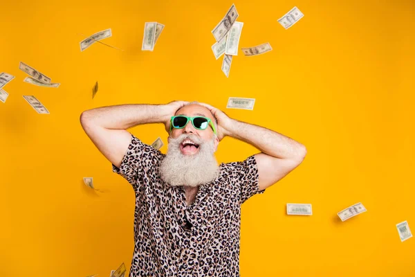 Portrait of shocked retired old bearded funny funky man in eyewear eyeglasses scream wow omg win victory look at money falling wear leopard shirt isolated over yellow background — Stock Photo, Image
