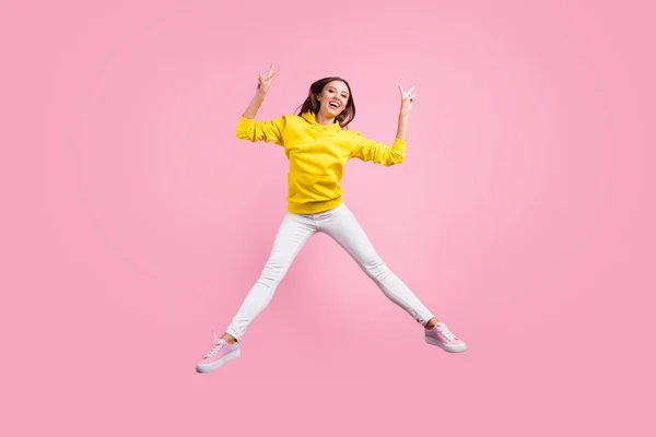 Фотография полного размера тела прыгающей симпатичной симпатичной симпатичной симпатичной девушки, на которой изображен V-образный знак в желтом свитере, изолированном на тротуаре — стоковое фото