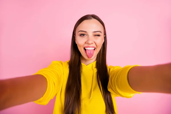 Self photo of cute nice charming pretty sweet girlfriend taking selfie showing you tongue while blinking flirty wearing yellow sweater isolated over pastel color background — Stock Photo, Image