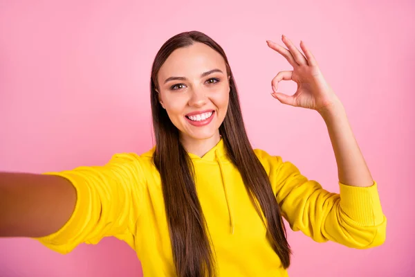 Autoritratto di allegro carino piuttosto dolce bella ragazza affascinante bruna dai capelli che ti mostra ok segno scattare selfie indossare maglione giallo mentre isolato su sfondo rosa pastello — Foto Stock