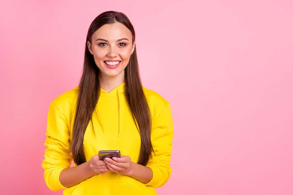 Foto van charmante aantrekkelijke leuke leuke vriendin met telefoon met haar handen ontvangen houdt van het dragen van gele trui geïsoleerd over pastel kleur achtergrond — Stockfoto