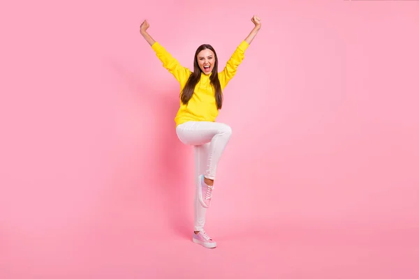 Фотография в полный рост, на которой очаровательная симпатичная симпатичная симпатичная симпатичная подруга поднимает ногу, как прыгает, радуясь продажам в желтом капюшоне, изолированном цветом пастели — стоковое фото